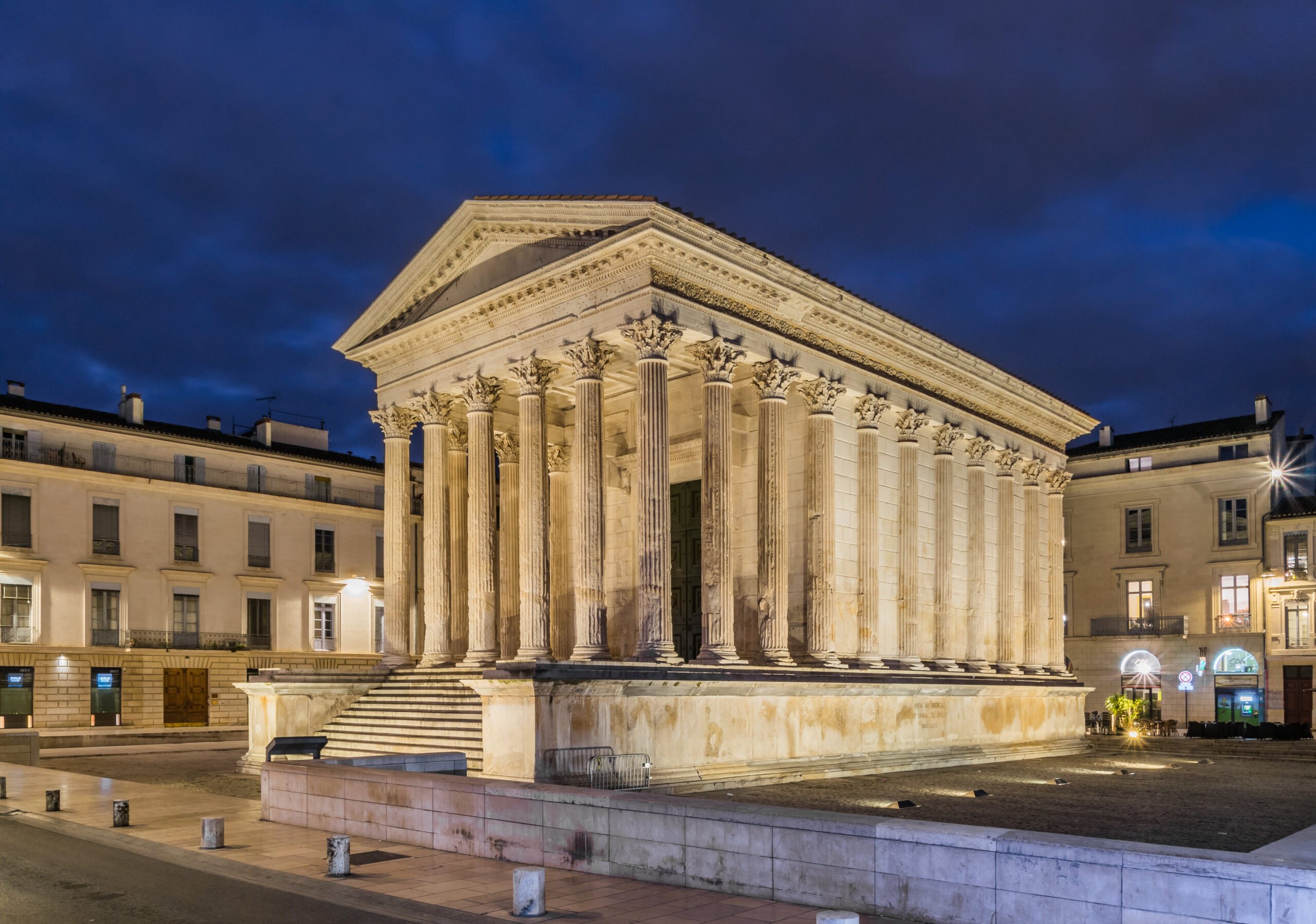 The illuminated Maison Carrée in Nîmes at dusk