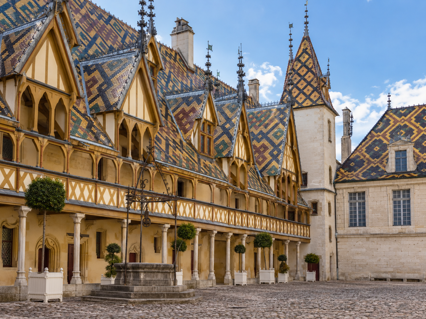Courtyard of the Hospices de Beaune with colorful glazed tile roofs in Burgundy, France