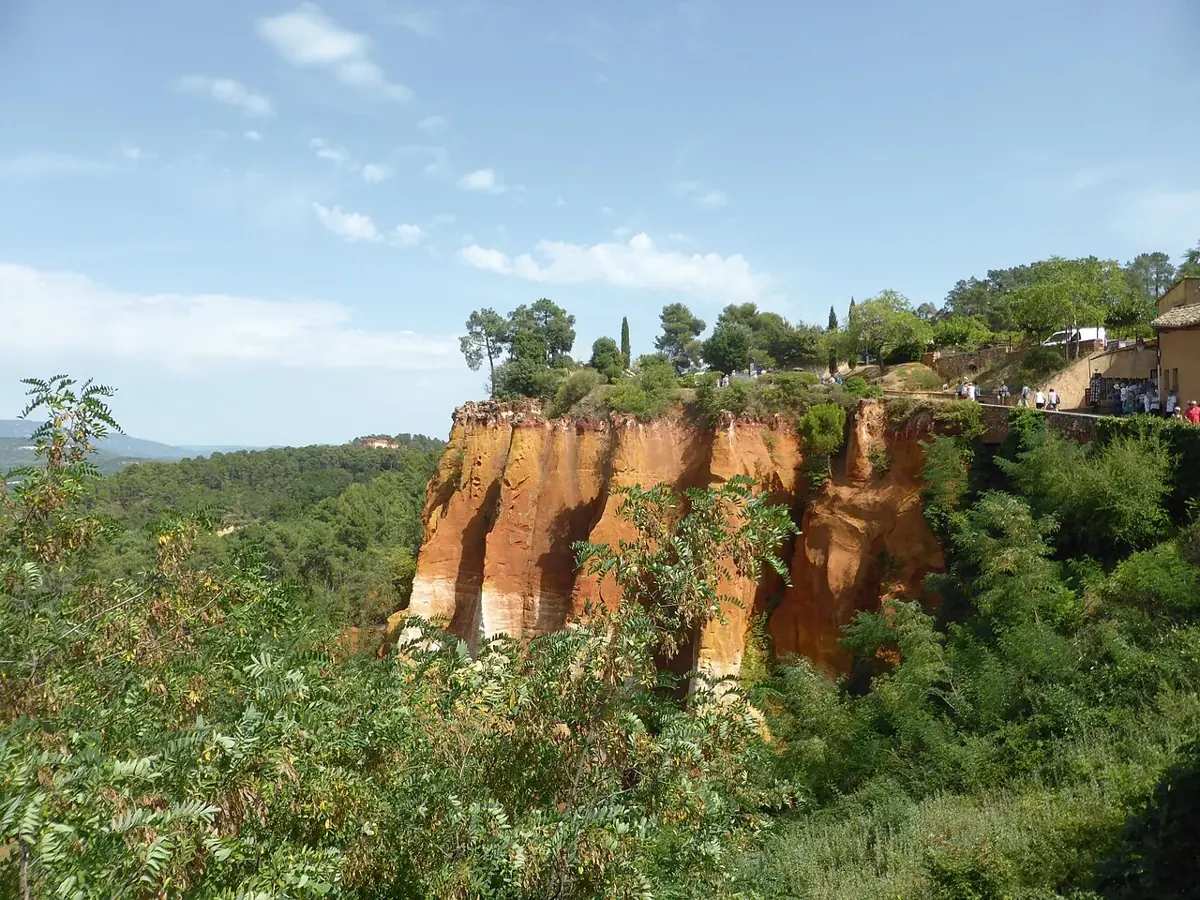 Golden ochre cliffs and pine trees on the Sentier des Ocres in Roussillon